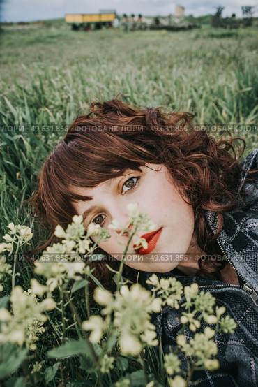 Young beautiful woman resting in a field of flowers. Стоковое фото, агентство Ingram Publishing / Фотобанк Лори