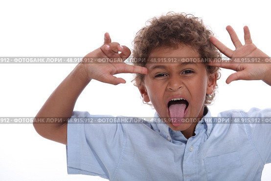 Young boy pulling a face and sticking his tongue out. Стоковое фото, агентство Ingram Publishing / Фотобанк Лори