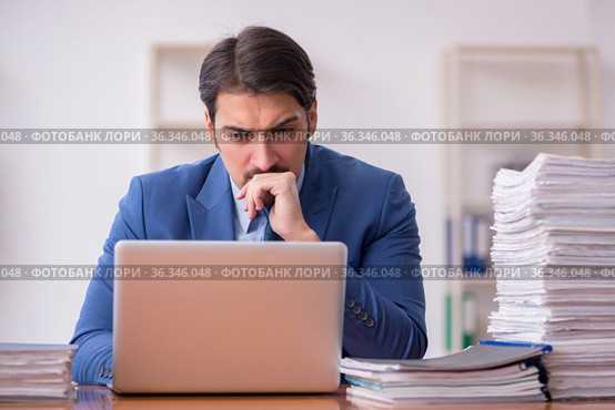 Young businessman employee and too much work in the office. Стоковое фото, фотограф Elnur / Фотобанк Лори