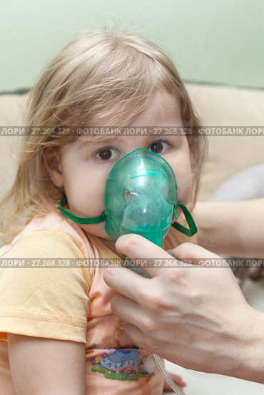 Young child doing inhalation with nebulizer at home. Mother hands holding mask (2011 год). Редакционное фото, фотограф Кекяляйнен Андрей / Фотобанк Лори