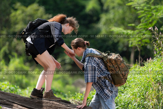 Young couple hiking in the forest with backpacks and trekking poles. Стоковое фото, агентство Ingram Publishing / Фотобанк Лори