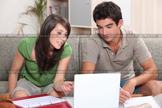 Young couple sitting on a sofa with a laptop. Стоковое фото, агентство Ingram Publishing / Фотобанк Лори