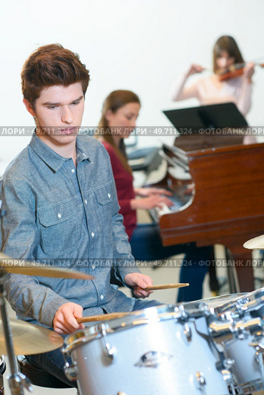 young drummer with drumsticks in a music class. Стоковое фото, агентство Ingram Publishing / Фотобанк Лори