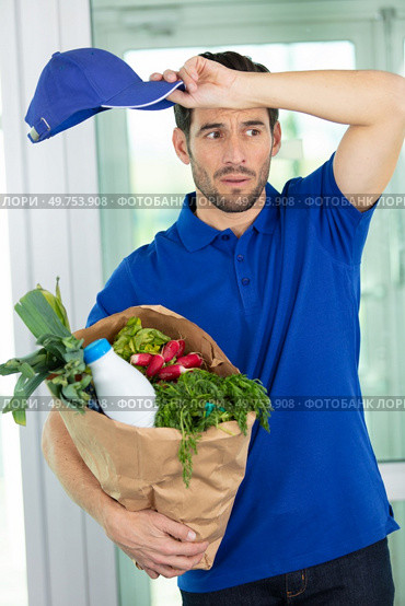 young exhausted deliveryman delivering groceries. Стоковое фото, агентство Ingram Publishing / Фотобанк Лори