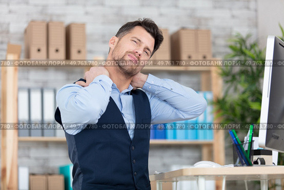 young frustrated freelancer is having a strong pain in neck. Стоковое фото, агентство Ingram Publishing / Фотобанк Лори