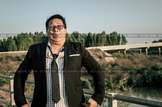 Young funny Asian Businessman wearing shirt and tie with shorts and eyeglasses in crazy and funny manner posture, copy space. Стоковое фото, агентство Ingram Publishing / Фотобанк Лори