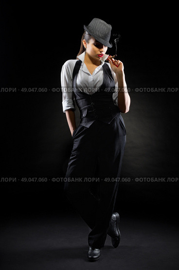 Young girl in manly style with cigar on black. Стоковое фото, агентство Ingram Publishing / Фотобанк Лори