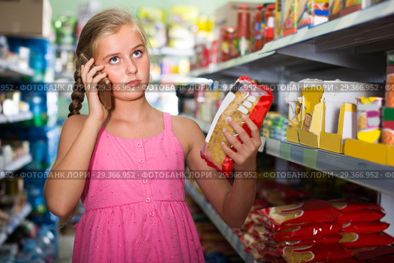 Young girl is advised by phone what pasta she should buy. Стоковое фото, фотограф Яков Филимонов / Фотобанк Лори