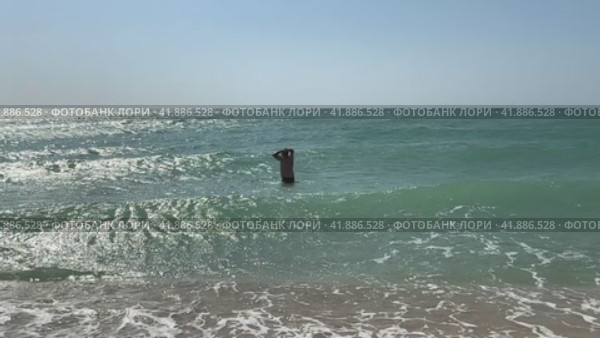 Young handsome man, bathing in the cold sea, trying to enter the water. Стоковое видео, видеограф Ирина Михайличенко / Фотобанк Лори