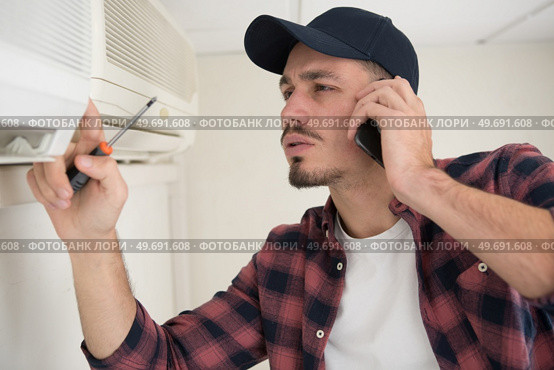 young happy male technician servicing ac. Стоковое фото, агентство Ingram Publishing / Фотобанк Лори