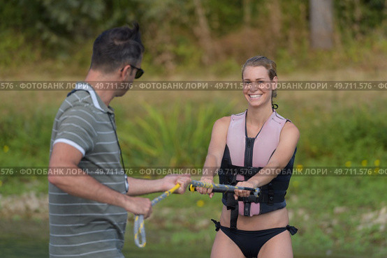 young happy woman learning water ski basics with coach. Стоковое фото, агентство Ingram Publishing / Фотобанк Лори