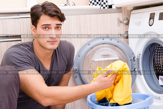 Young husband man doing laundry at home. Стоковое фото, фотограф Elnur / Фотобанк Лори