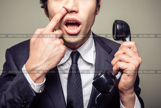 Young incompetent businessman is on the phone and is picking his nose. Стоковое фото, агентство Ingram Publishing / Фотобанк Лори