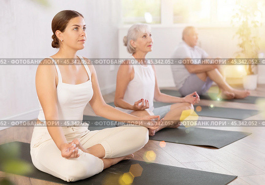 Young lady performs comfortable lotus asana-Padmasana-Siddhasana pose. Стоковое фото, фотограф Яков Филимонов / Фотобанк Лори