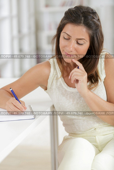 young lady writing list at home. Стоковое фото, агентство Ingram Publishing / Фотобанк Лори