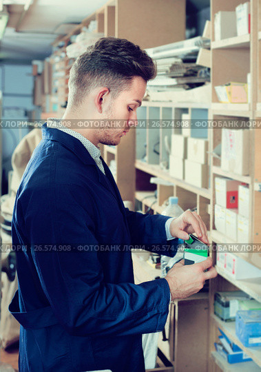 Young male joiner searching for items at workplace. Стоковое фото, фотограф Яков Филимонов / Фотобанк Лори