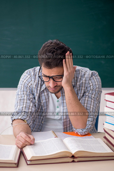 Young male teacher suffering in the classroom. Стоковое фото, фотограф Elnur / Фотобанк Лори