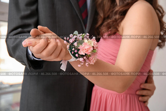 Young man and his prom date with corsage holding hands, closeup. Стоковое фото, фотограф Pixel_shot / Фотобанк Лори
