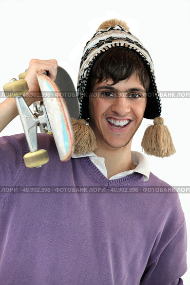 Young man carrying a skateboard. Стоковое фото, агентство Ingram Publishing / Фотобанк Лори