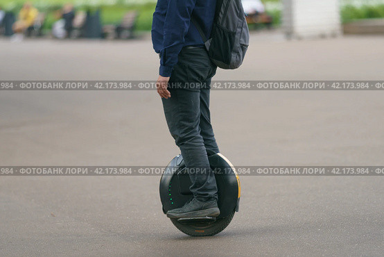 Young man driving Electric unicycle on the Moscow city center. He know how to be fast in the city during coronavirus pandemic time. No traffic. Стоковое фото, фотограф YuryKara / Фотобанк Лори