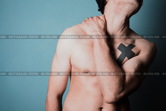 Young man is in pain and is massasing his sore neck. Стоковое фото, агентство Ingram Publishing / Фотобанк Лори