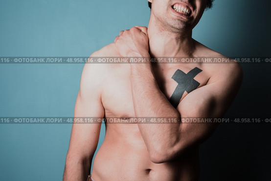 Young man is in pain and is massasing his sore neck. Стоковое фото, агентство Ingram Publishing / Фотобанк Лори
