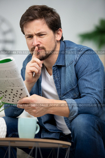 young man is thinking about a crossword puzzle. Стоковое фото, агентство Ingram Publishing / Фотобанк Лори