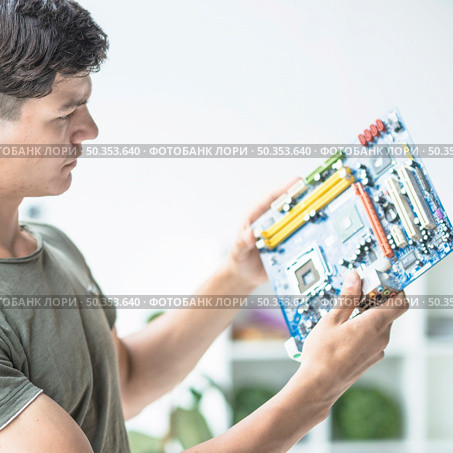 young man looking motherboard circuit. Стоковое фото, агентство Ingram Publishing / Фотобанк Лори