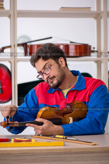 Young man repairing musical instruments at workshop. Стоковое фото, фотограф Elnur / Фотобанк Лори