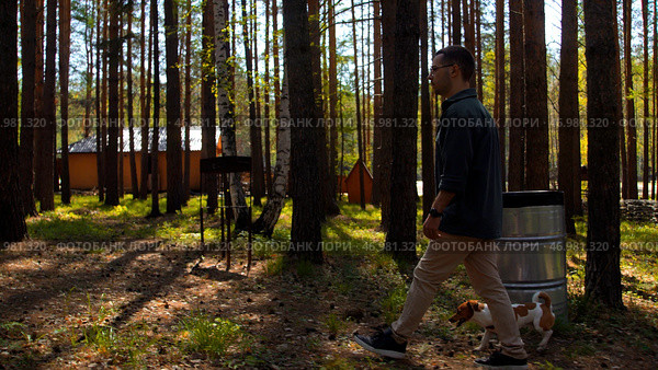 Young man with a jack russell puppy outdoors at the countryside camping. Стоковое фото, фотограф David Kashakhi / Фотобанк Лори