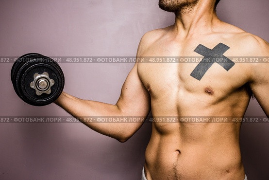 Young man working out with dumbbell. Стоковое фото, агентство Ingram Publishing / Фотобанк Лори