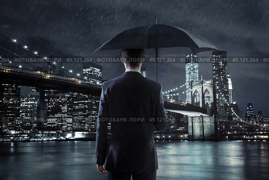 Young manager with an umbrella over the night city background. Стоковое фото, агентство Ingram Publishing / Фотобанк Лори