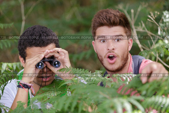 young men seeking with binocular something. Стоковое фото, агентство Ingram Publishing / Фотобанк Лори