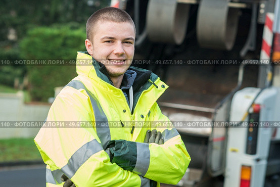 young municipal garbage collector near garbage truck. Стоковое фото, агентство Ingram Publishing / Фотобанк Лори