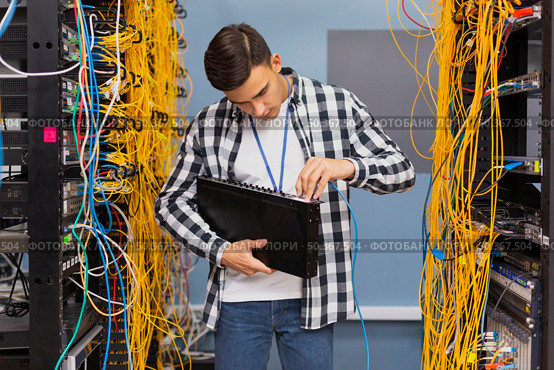 young network engineer holding ethernet switches. Стоковое фото, агентство Ingram Publishing / Фотобанк Лори