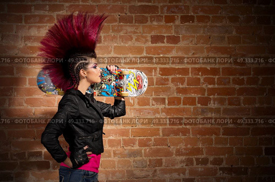 Young punk girl on brick wall background. Стоковое фото, агентство Ingram Publishing / Фотобанк Лори