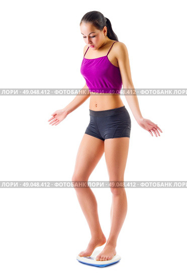 Young sporty woman on scales isolated. Стоковое фото, агентство Ingram Publishing / Фотобанк Лори