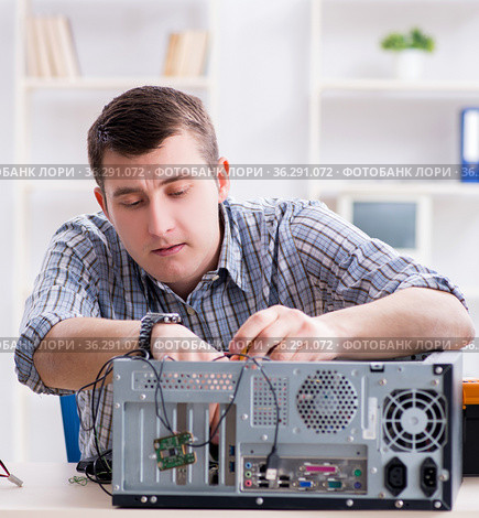 Young technician repairing computer in workshop. Стоковое фото, фотограф Elnur / Фотобанк Лори