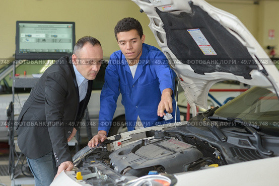 young tinker showing his colleague some problems. Стоковое фото, агентство Ingram Publishing / Фотобанк Лори
