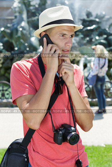 young tourist with worry expression talking on phone. Стоковое фото, агентство Ingram Publishing / Фотобанк Лори