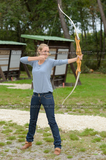 young woman aiming with a bow. Стоковое фото, агентство Ingram Publishing / Фотобанк Лори