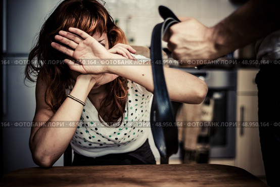 Young woman being threatened with a belt by her partner. Стоковое фото, агентство Ingram Publishing / Фотобанк Лори