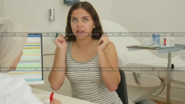 Young woman consulting with faceless beautician on anti-aging treatments in cosmetology clinic. Стоковое видео, видеограф Яков Филимонов / Фотобанк Лори