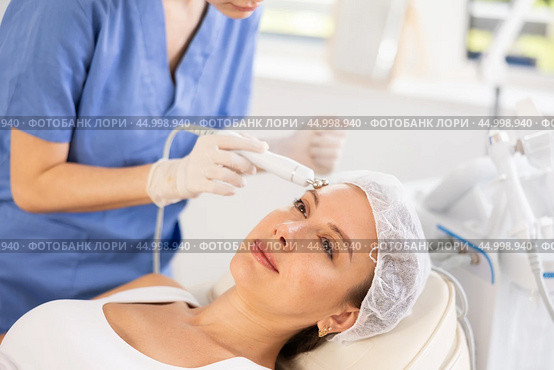 Young woman cosmetologist doing microcurrent procedure to young woman. Стоковое фото, фотограф Яков Филимонов / Фотобанк Лори