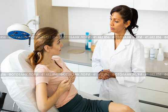 Young woman discussing breast augmentation with female doctor. Стоковое фото, фотограф Яков Филимонов / Фотобанк Лори