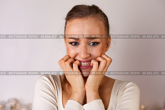 Young Woman Expressing Anxiety and Uncertainty in a Studio Setting With a Plain Background. Стоковое фото, фотограф Aleksandr Golubev / Фотобанк Лори