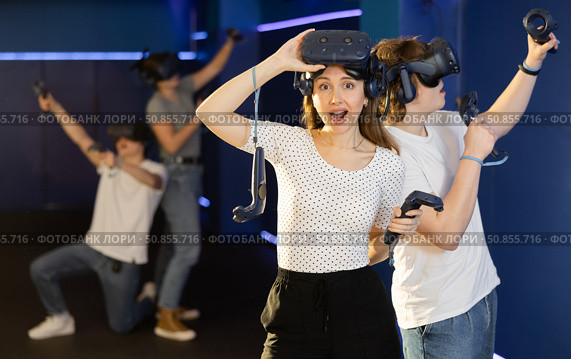 Young woman having fun with friends in virtual reality room. Стоковое фото, фотограф Яков Филимонов / Фотобанк Лори