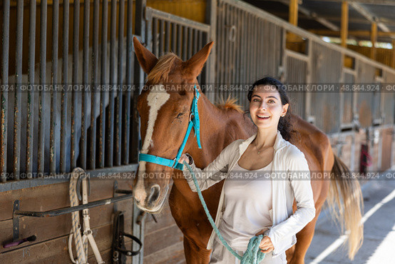 Young woman leads horse out of stable. Стоковое фото, фотограф Яков Филимонов / Фотобанк Лори