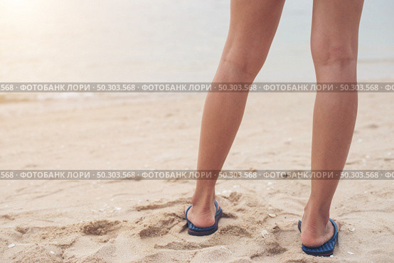 Young woman legs in flipflop sandals on sea beach. Стоковое фото, агентство Ingram Publishing / Фотобанк Лори
