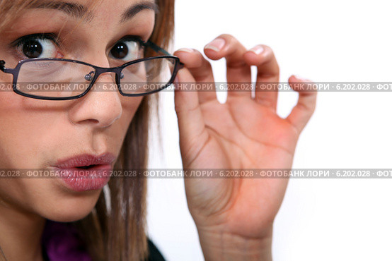 young woman looked amazed, she's lowering her glasses. Стоковое фото, фотограф Phovoir Images / Фотобанк Лори